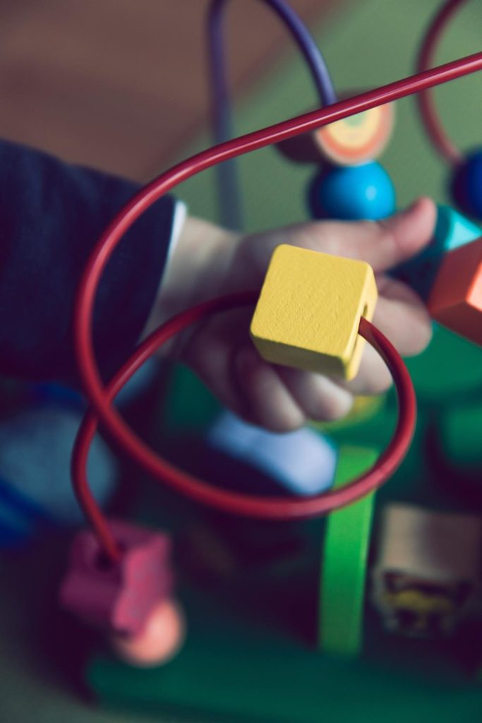 Niño jugando con un cubo de actividades en una terapia ocupacional infantil